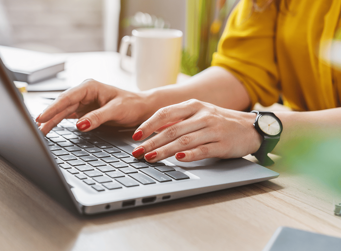 Woman Wearing a Watch Typing on Laptop