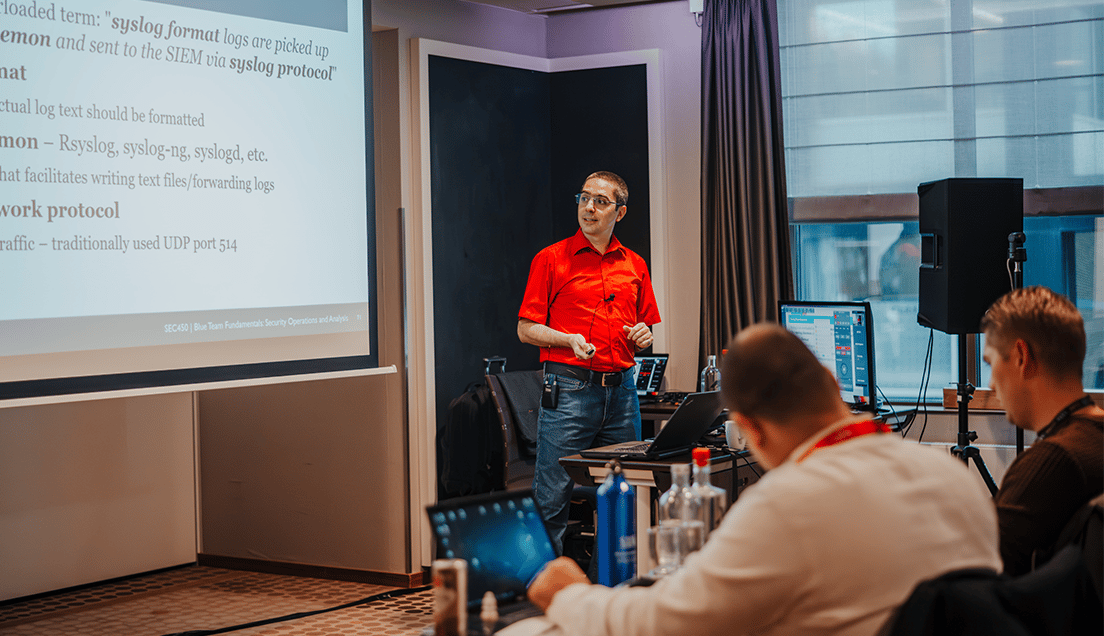 Teacher In Red Shirt Reviewing Content On Large Screen