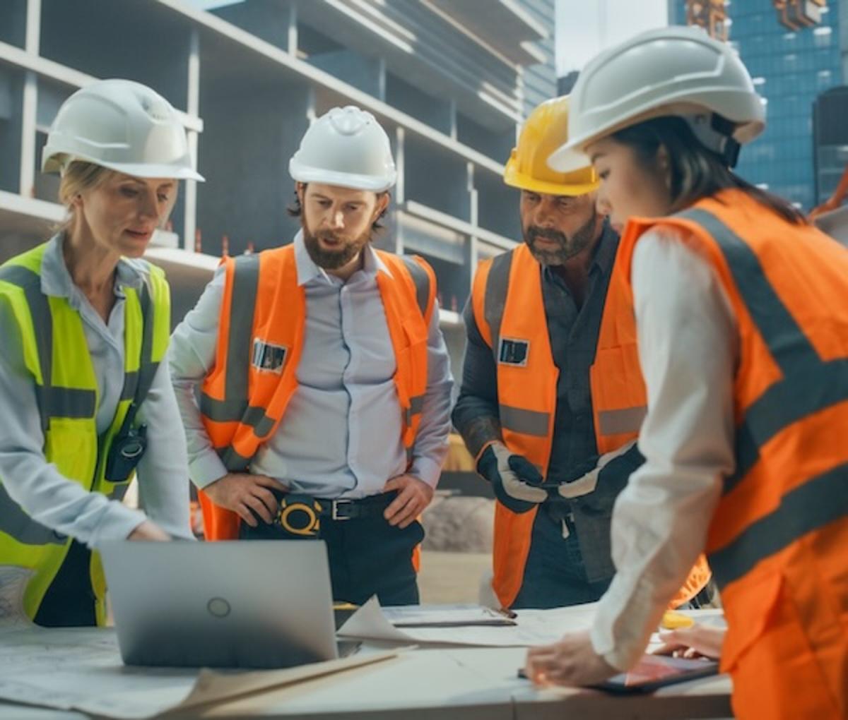 Construction workers looking at a laptop