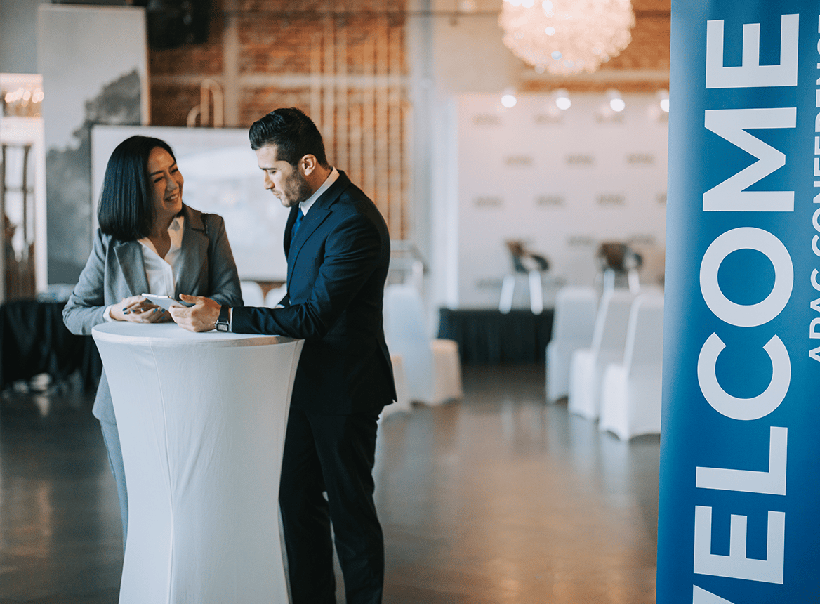 Two People Looking at a Tablet in a Ballroom