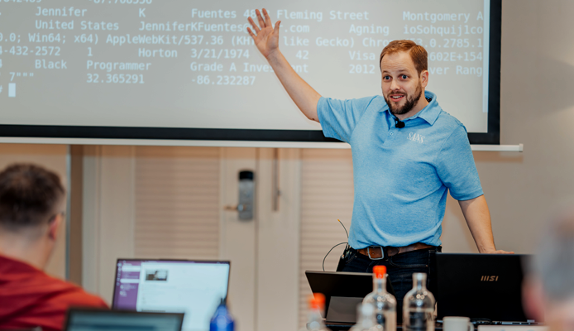 SANS Teacher in Blue Shirt Explaining a Concept