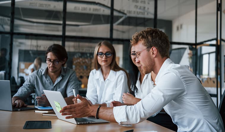 Four People Gathered at Conference Table and Discussing an Issue