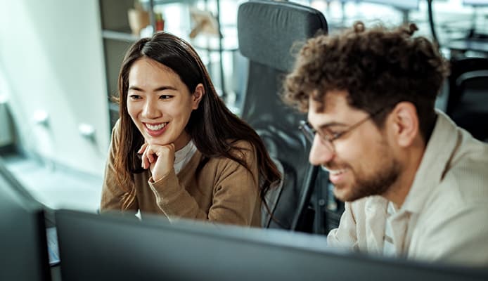 Two People Smiling at a Computer