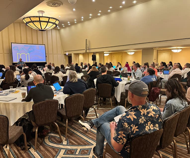 People Watching a Presentation in A Summit Room