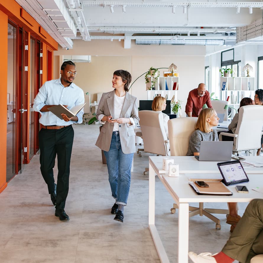 Two People Walking and Talking in Office