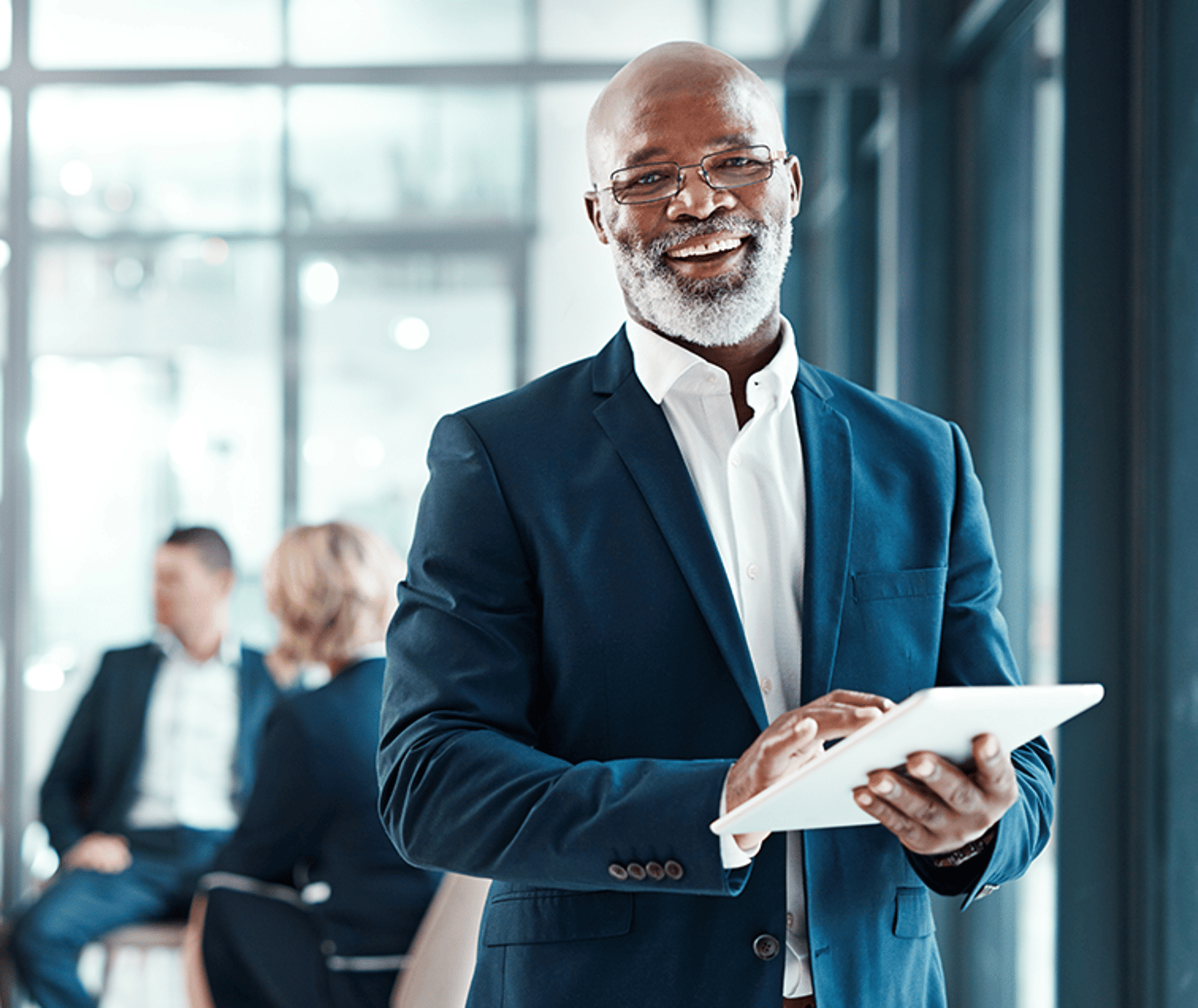 Man Smiling at the Camera and Holding Tablet