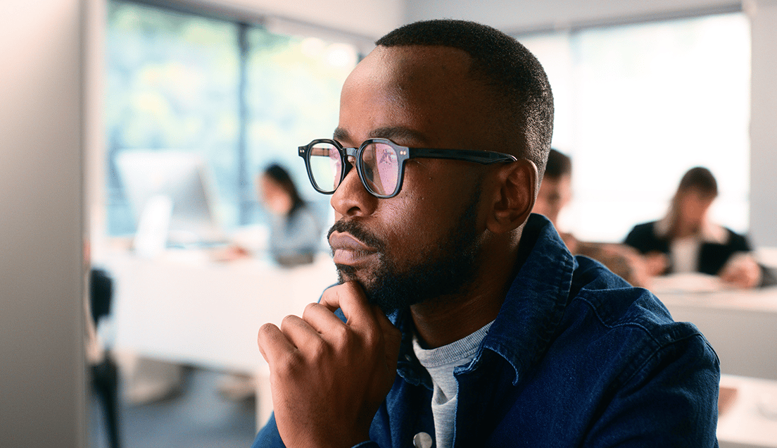 Pensive Man Touching His Chin in an Office Setting