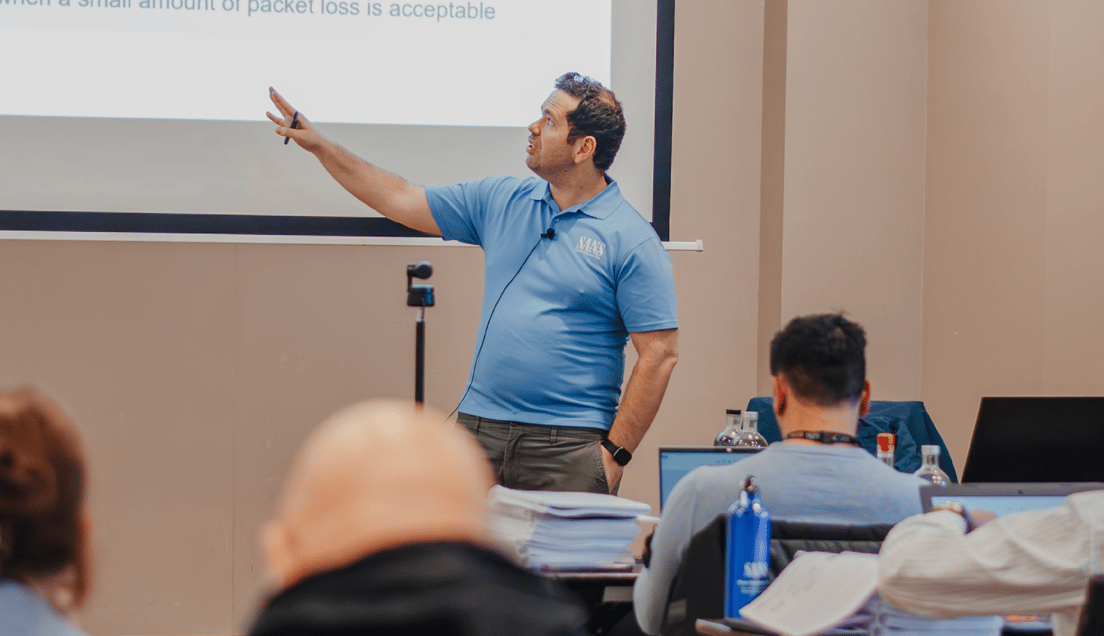 Teacher in Blue Shirt Explaining Material On Large Screen