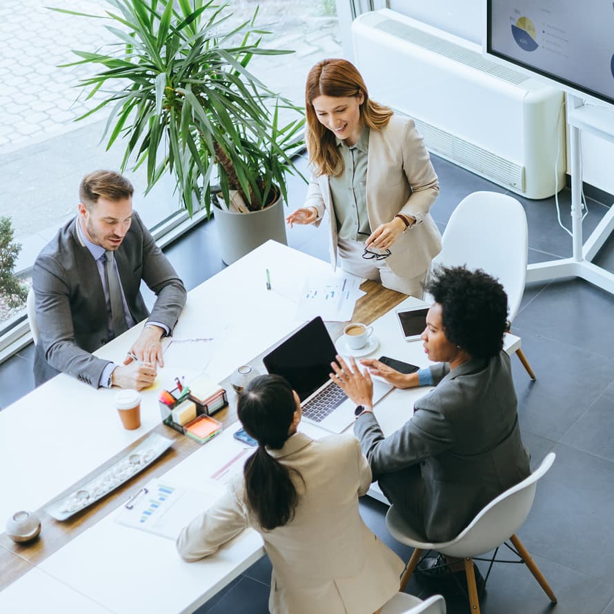 Overhead View of Four People Working at a Shared Desk