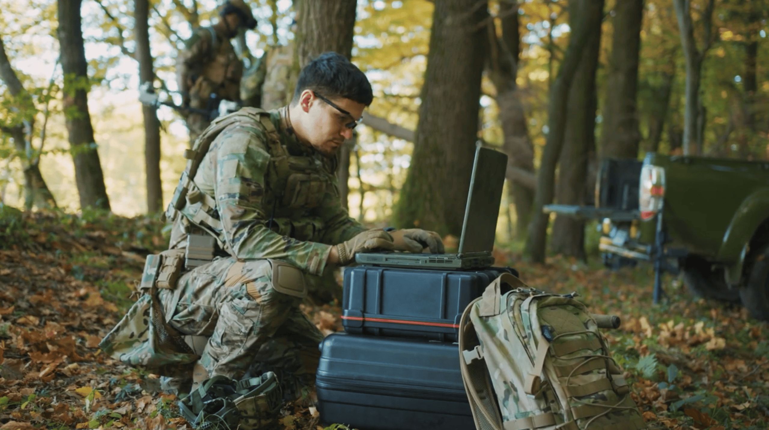 Soldier on the battlefield typing on a laptop