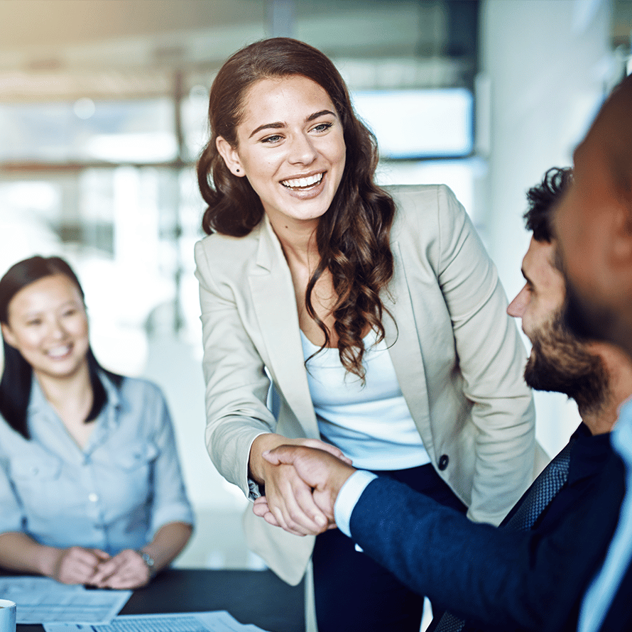 A Woman Shaking Hands and Smiling at a Meeting
