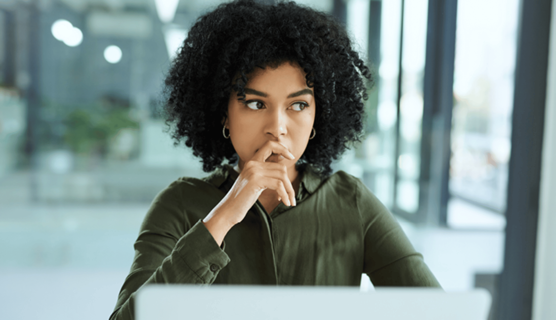 Woman Looking Thoughtful and Holding Hand Up Over Her Mouth