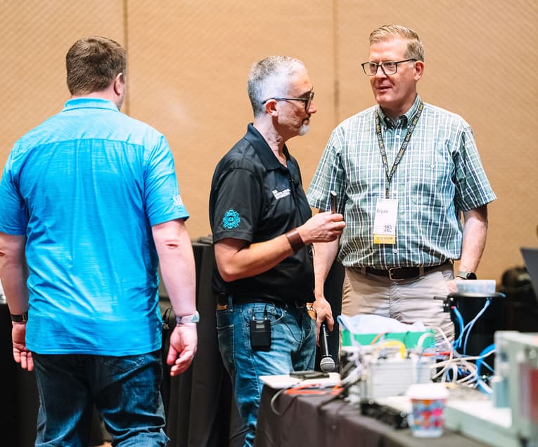 SANS ICS Security Summit 2026: Men Standing Together In Summit Room