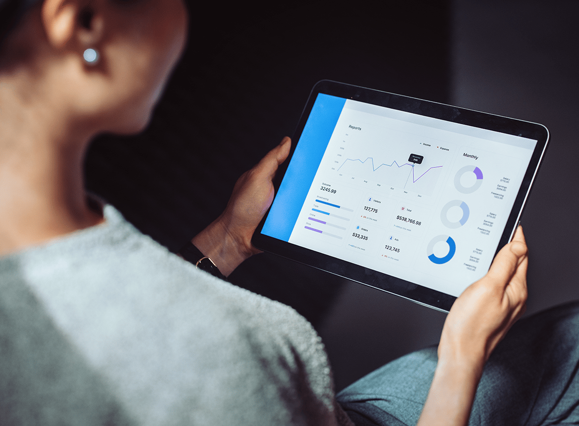 Woman Holding Tablet with Data and Graphs