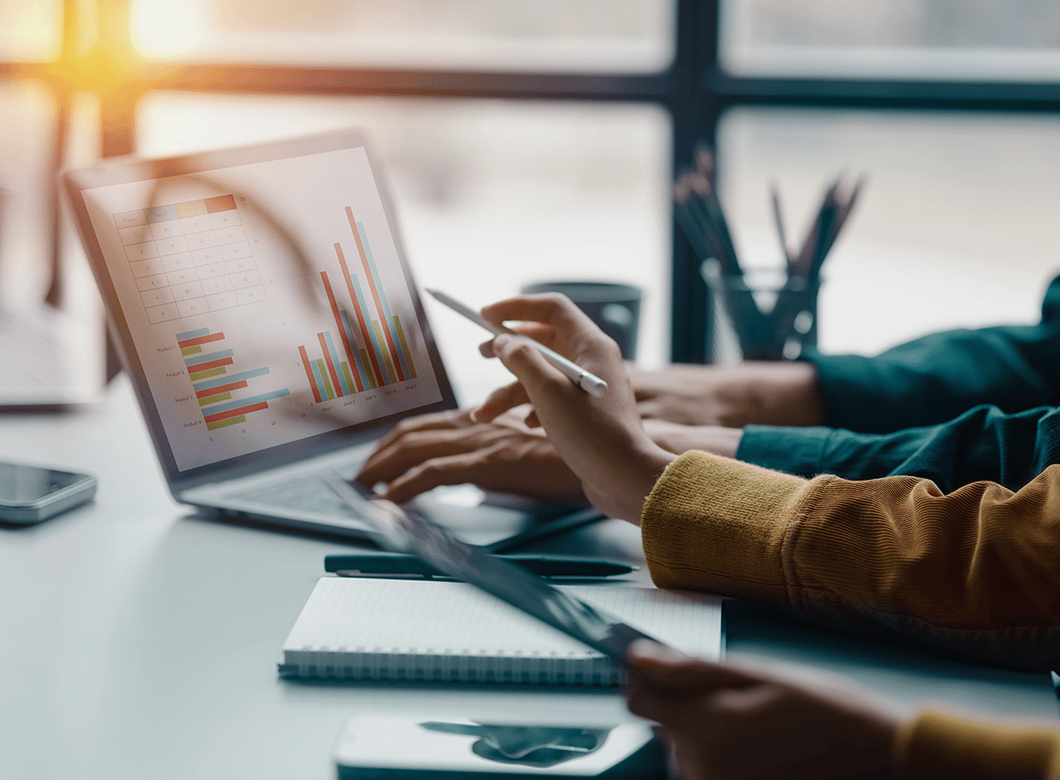 A Hand Pointing at a Graph on a Laptop