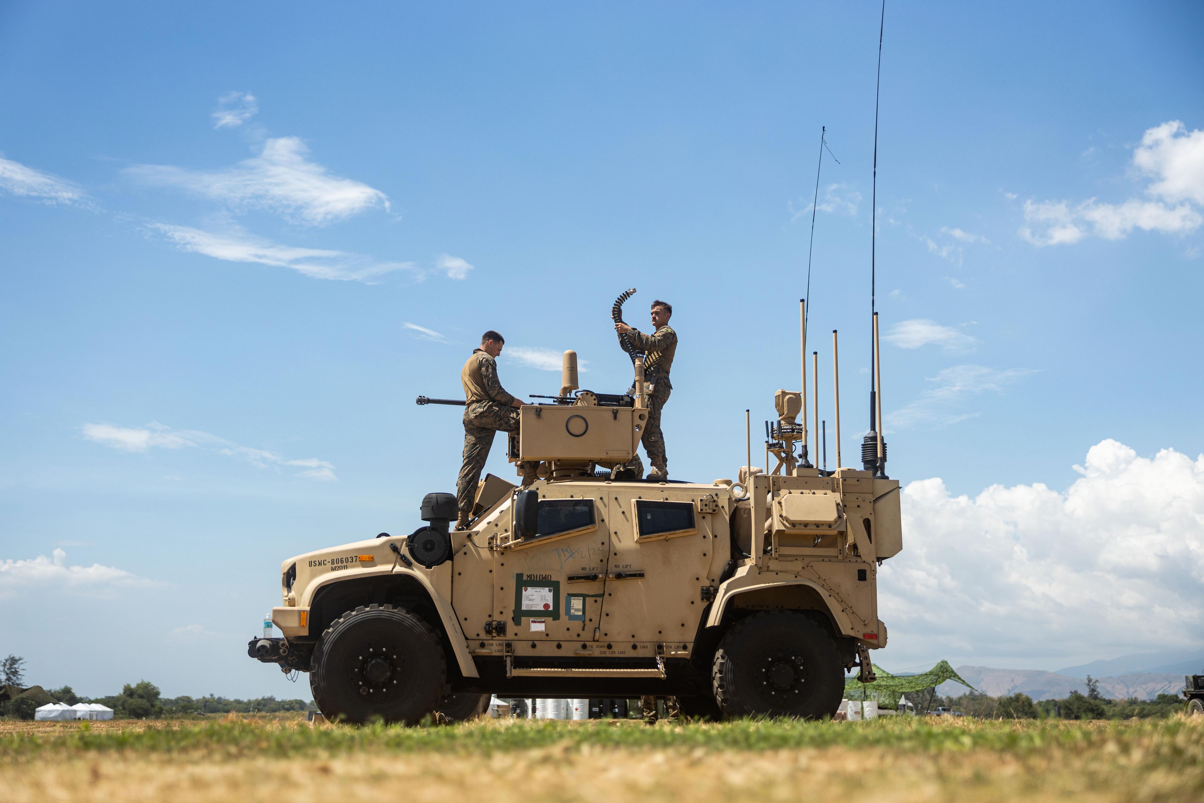Soldiers standing on military vehicle