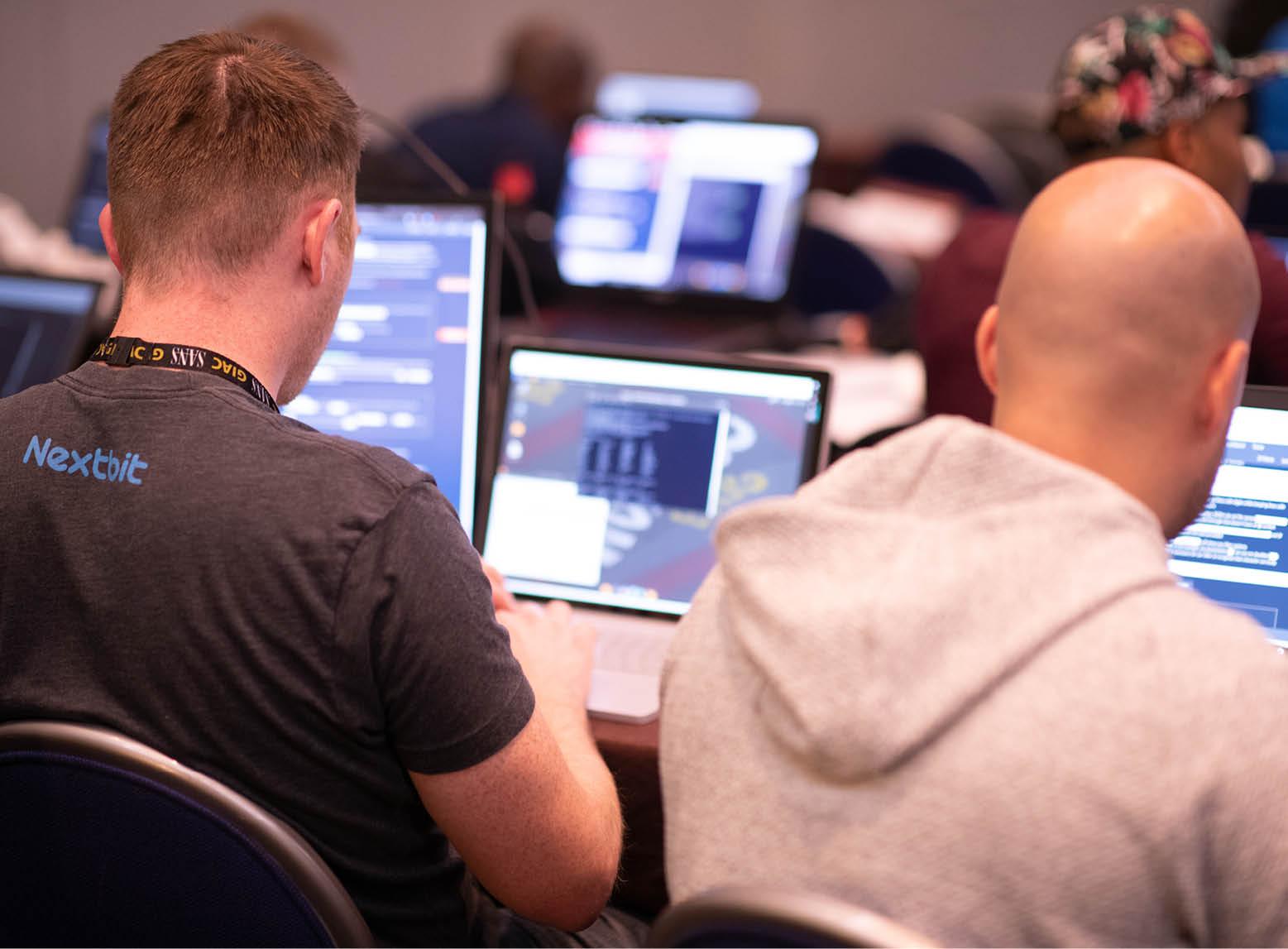 Two Men at Laptops Training with SANS