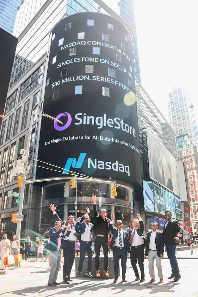 SingleStore team celebrating at the Nasdaq building, in front of a billboard that reads "Nasdaq Congratulates SingleStore on Securing $80 Million Series F Funding".