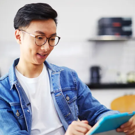 Adulto realiza una prueba de nivel de inglés en una tablet en casa, como parte de un programa de aprendizaje de idiomas de Berlitz.