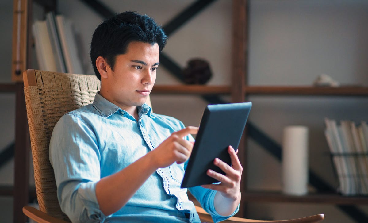 Man learning English courses online from home through Berlitz’s flexible virtual platform on a tablet.