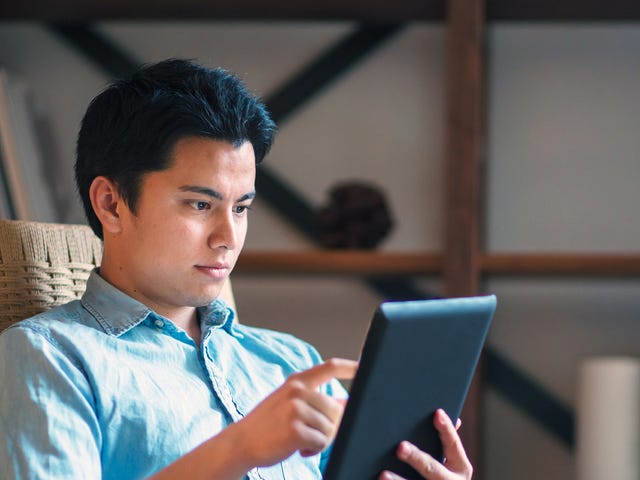 Man learning English courses online from home through Berlitz’s flexible virtual platform on a tablet.