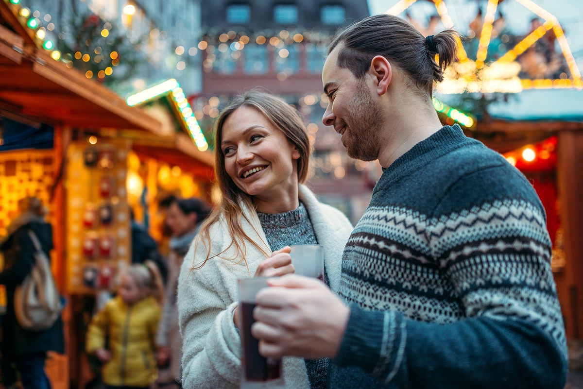 Friends laughing and  enjoying the Christmas market in Germany, get to know German expressions.