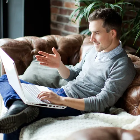 Smiling man learning from home on a video call, representing flexibility and comfort with Berlitz online language schools.
