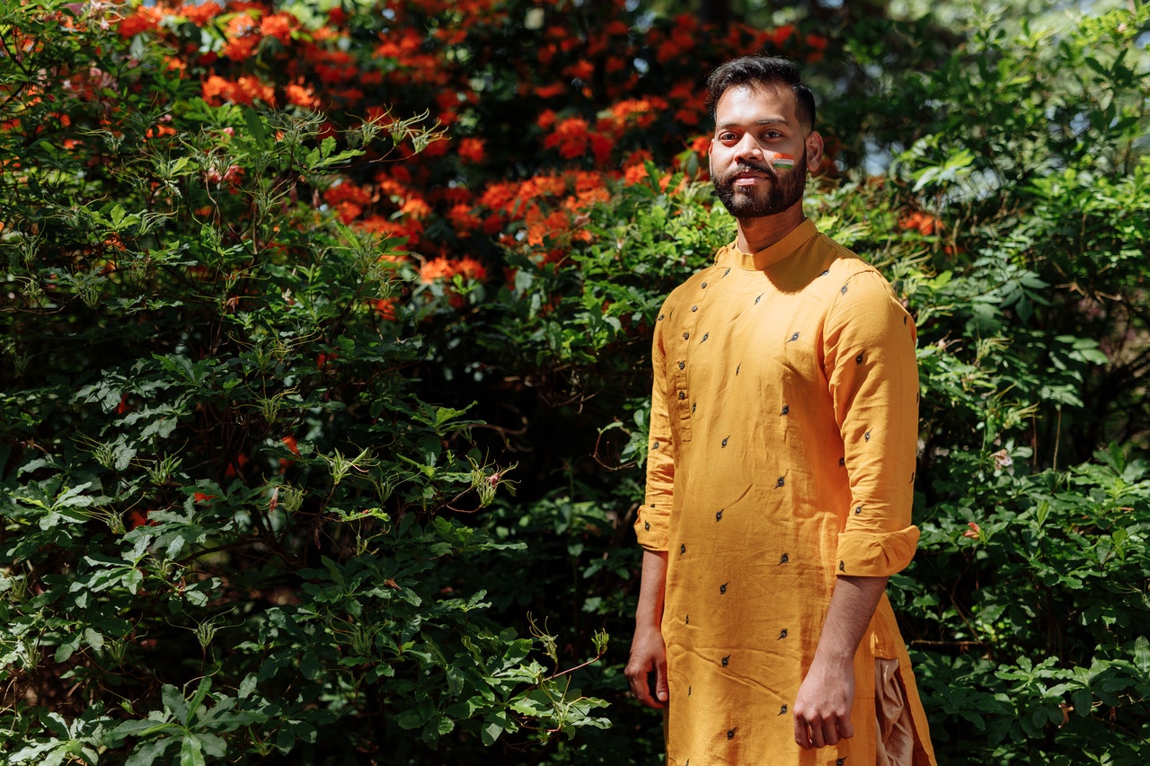 Man standing in green garden wearing traditional Indian garments