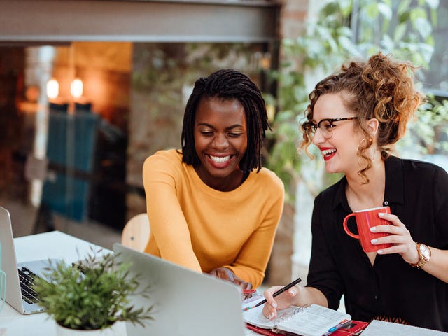 Two women collaborating in a modern office, capturing the dynamic and supportive work culture promoted through Berlitz careers.