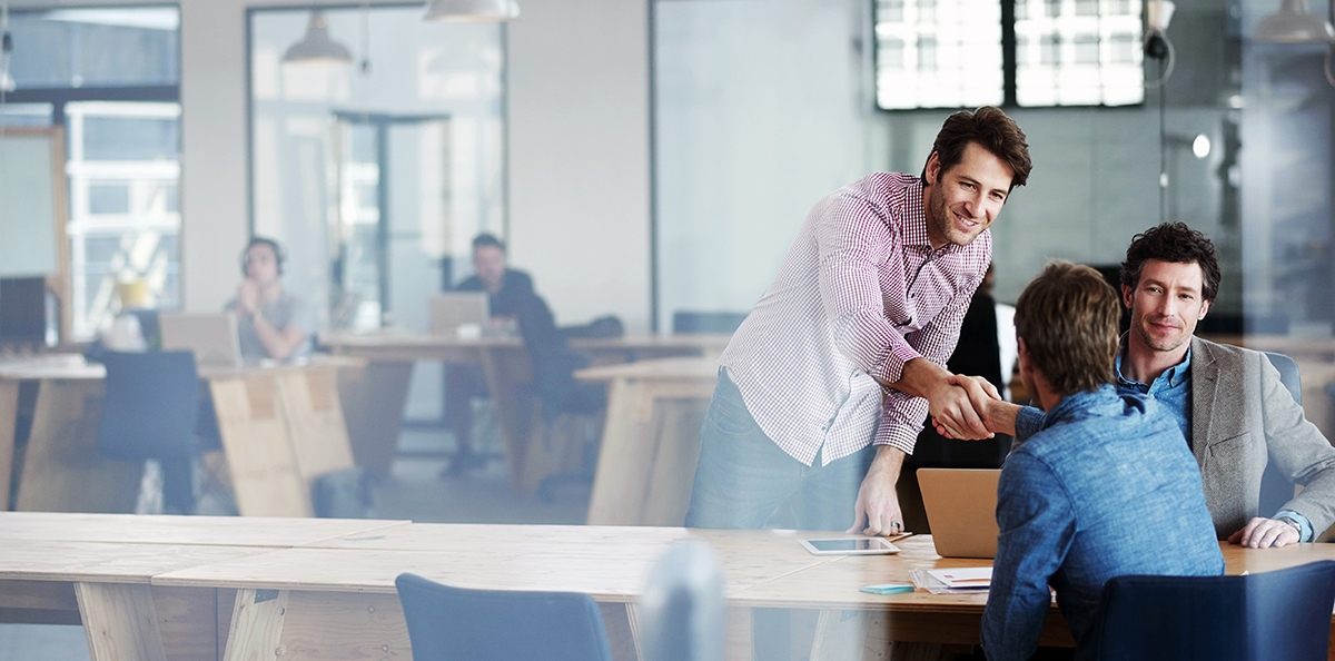 Man shakes hands with a potential business partner during a business meeting in Spanish.