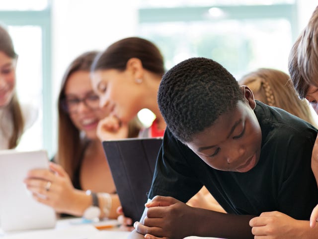 Children working together on tablets in a classroom setting, showcasing Berlitz language school’s interactive and tech-integrated learning approach.