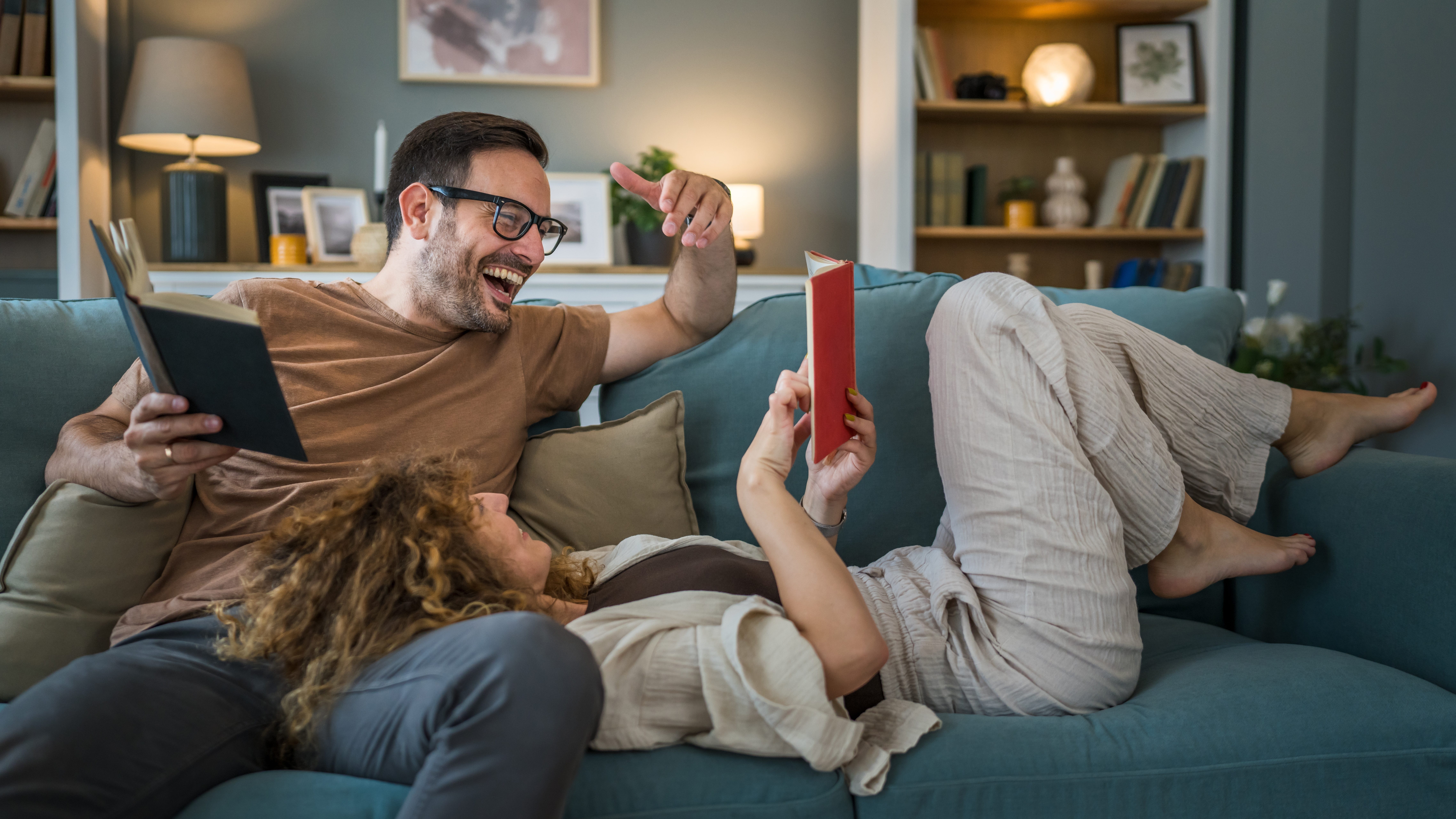 couple sitting together, reading books and having laugh