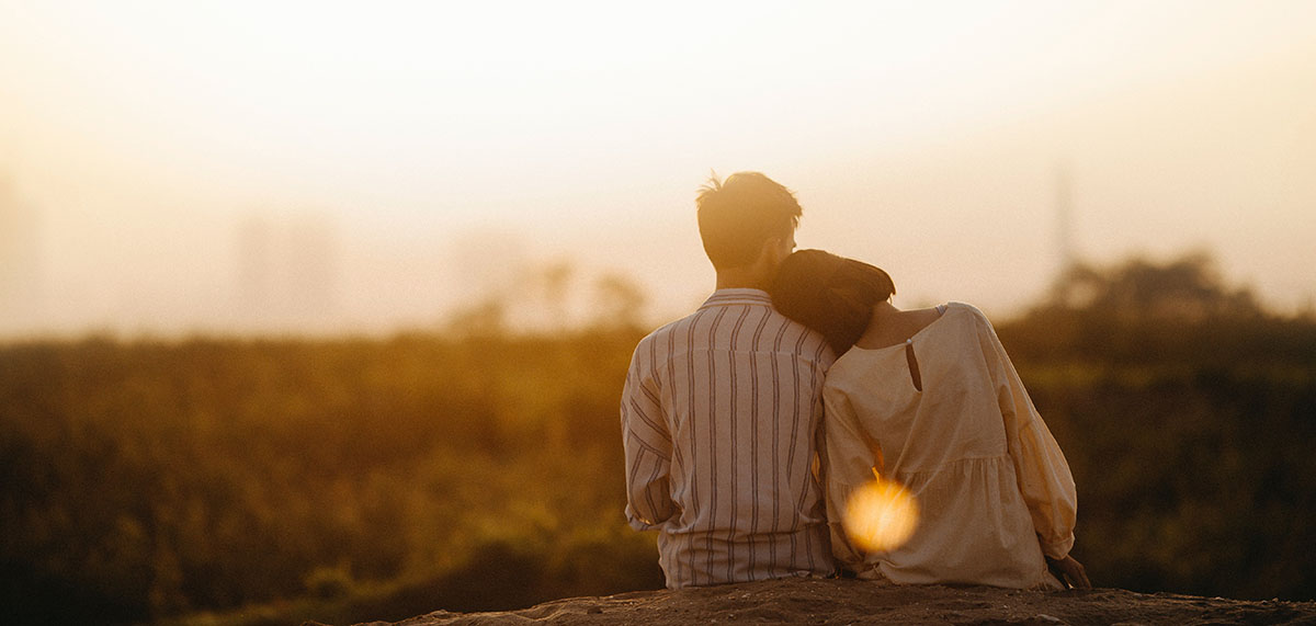 Couple watching the sunset saying French words about love