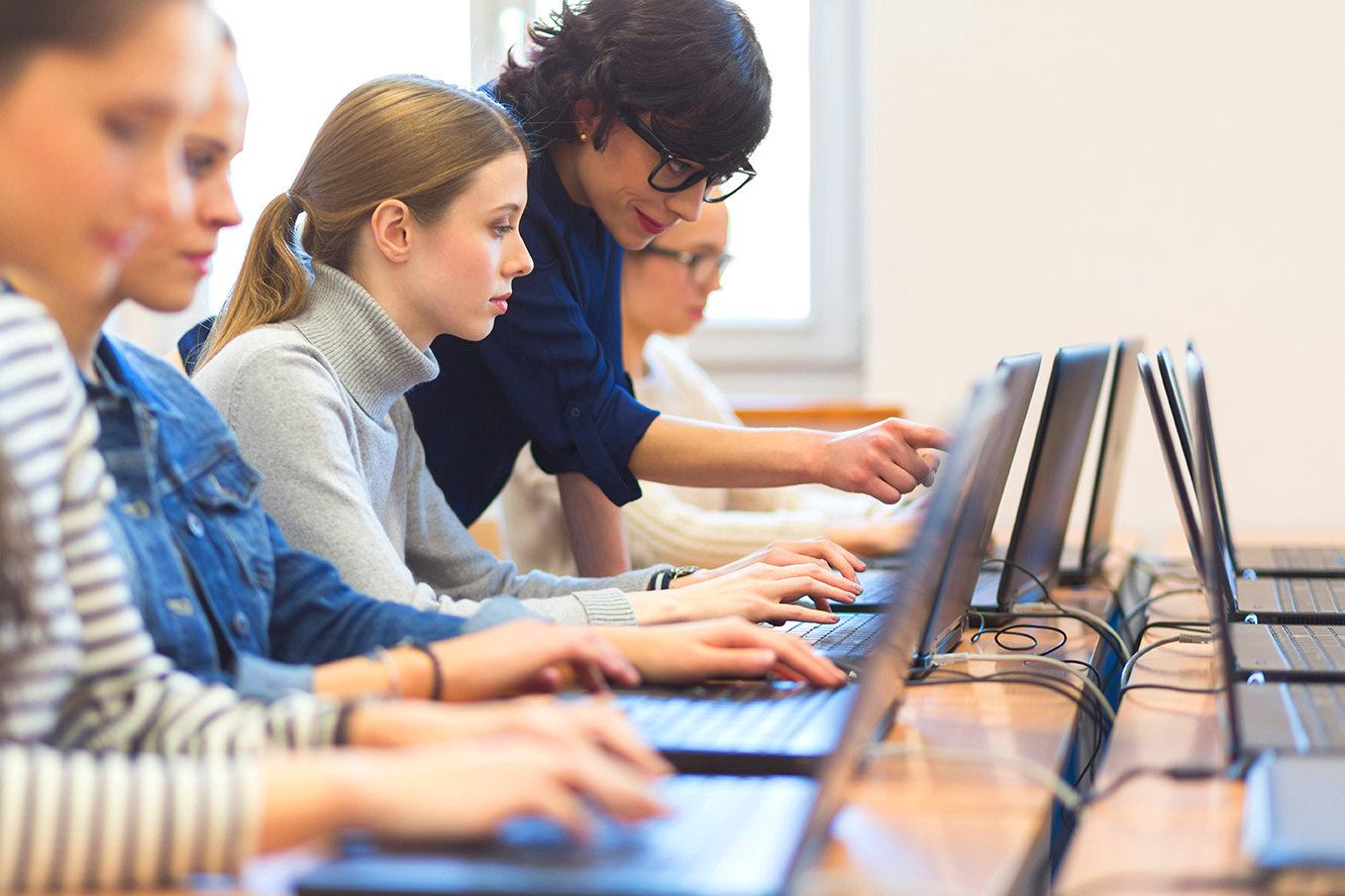 Teacher helping a student in a live classroom environment