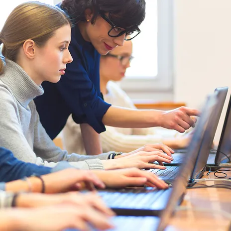 Teacher helping a student in a live classroom environment