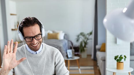 Man attending an online Czech language course via video call from his home office