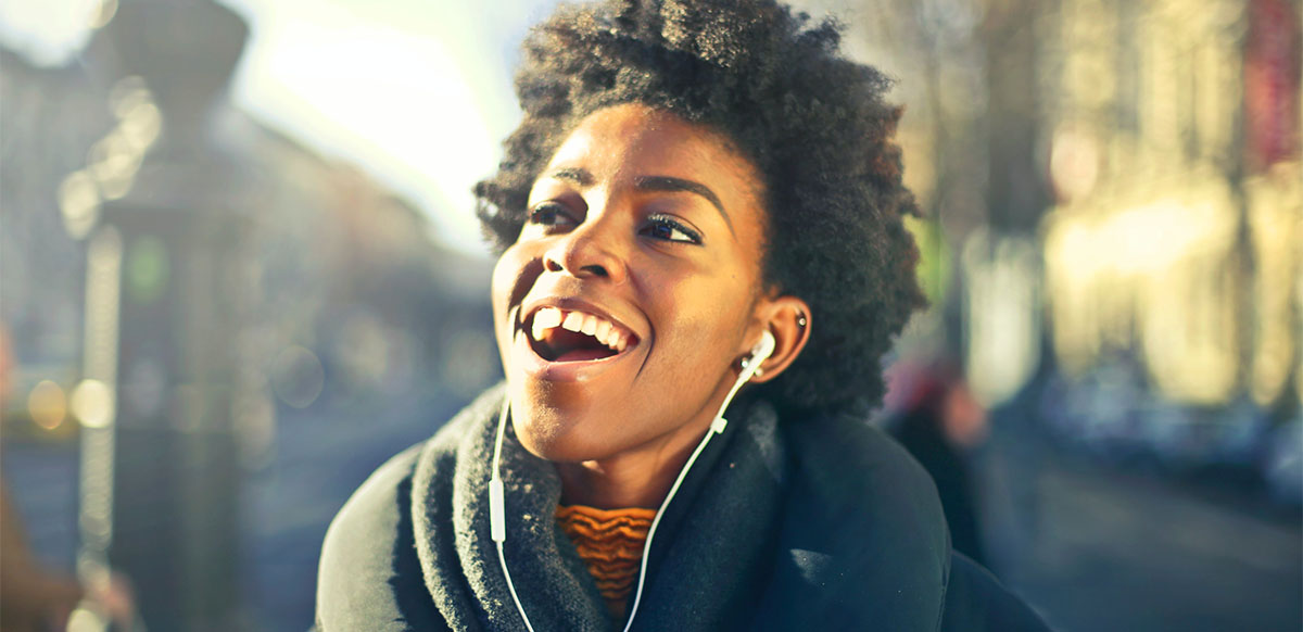 Woman Listening to music with irregular verbs.