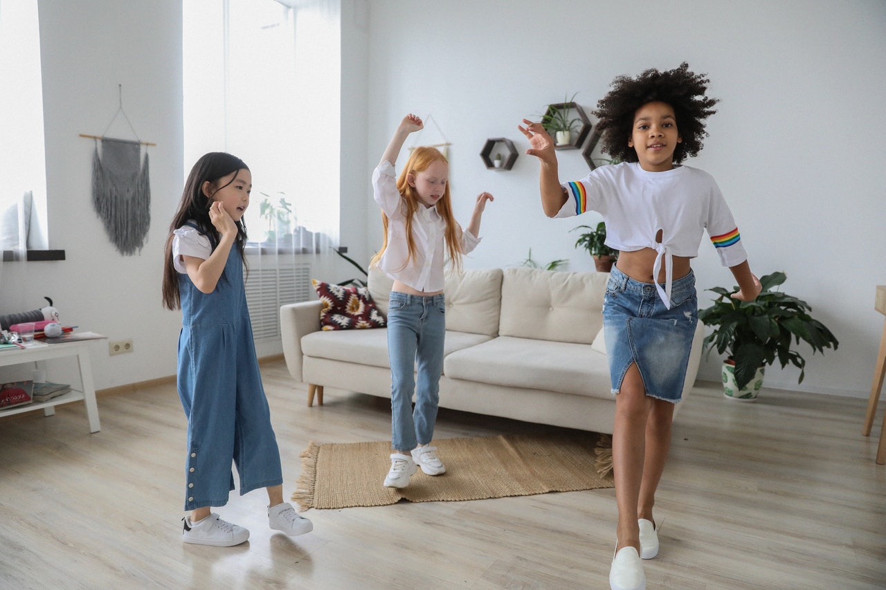 Young girls dancing in living room.