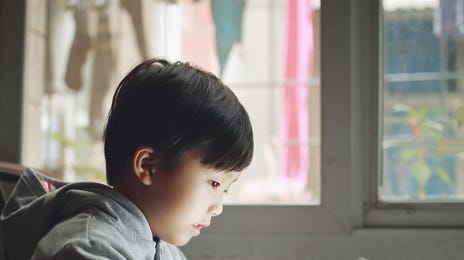 Young boy using a tablet to attend an online French class at home