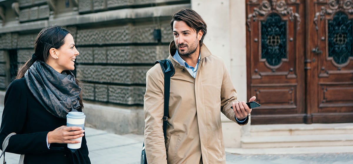 Man compliments his colleague on her work in Italian.