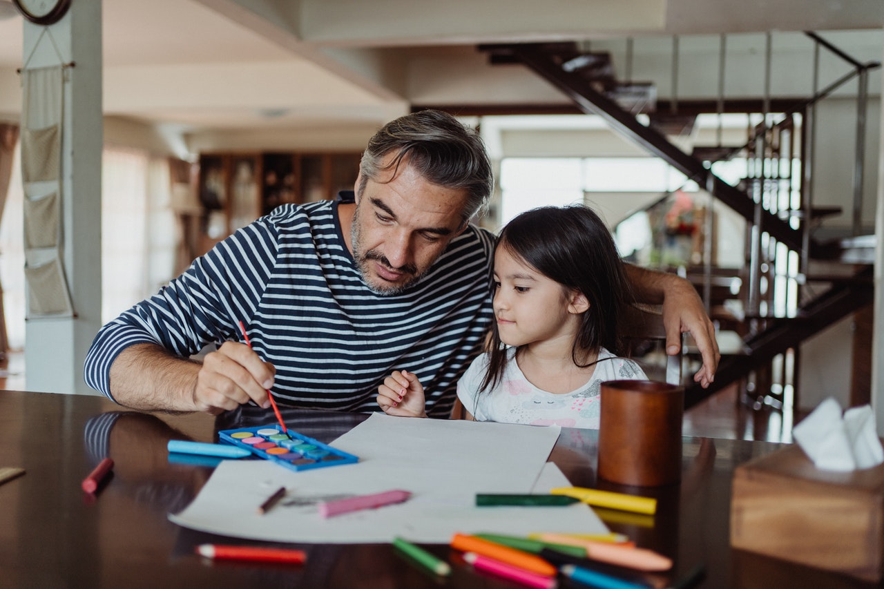 Father and daughter play games to help learn the days of the week in Spanish.