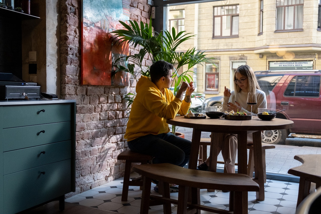 Man and woman learn sign language at a cafe.