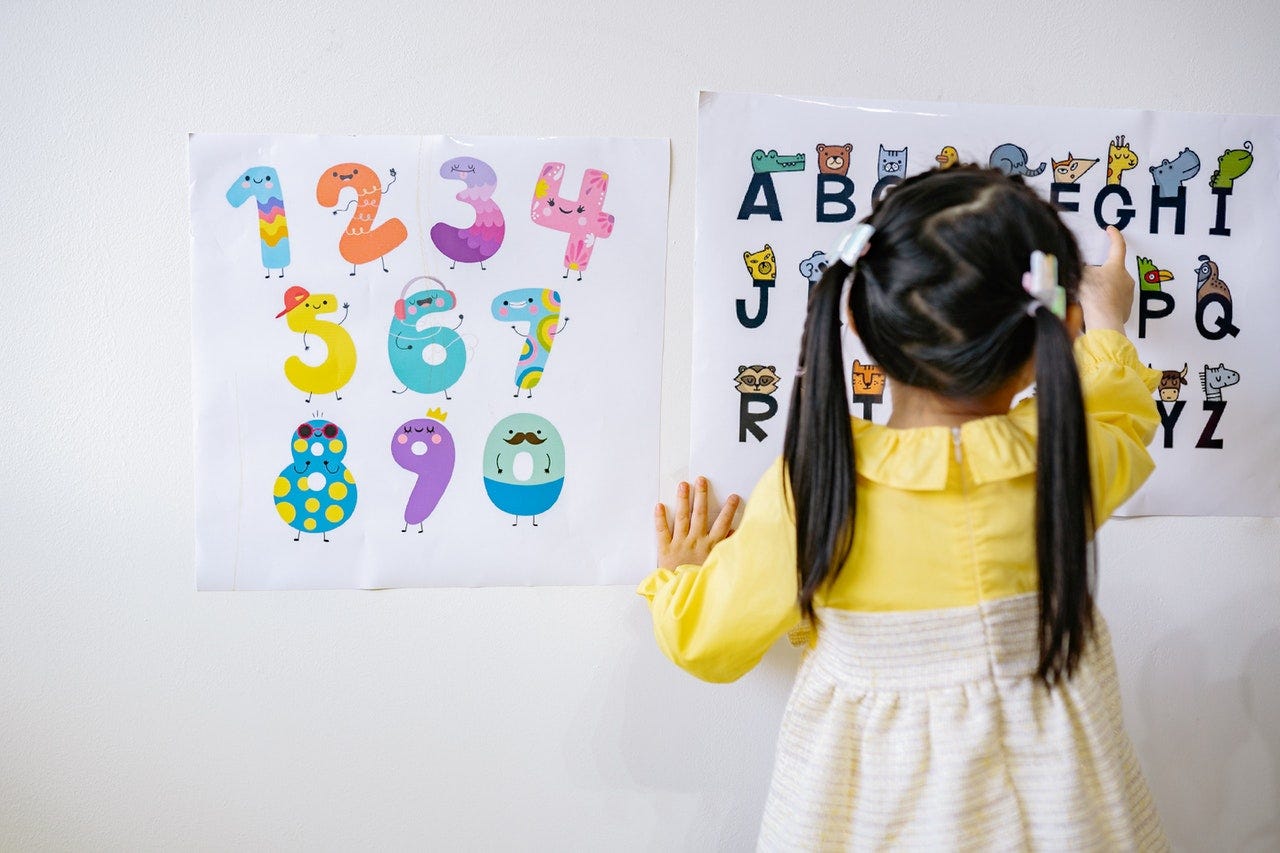 Young girl is using images and pictures to learn numbers and the alphabet