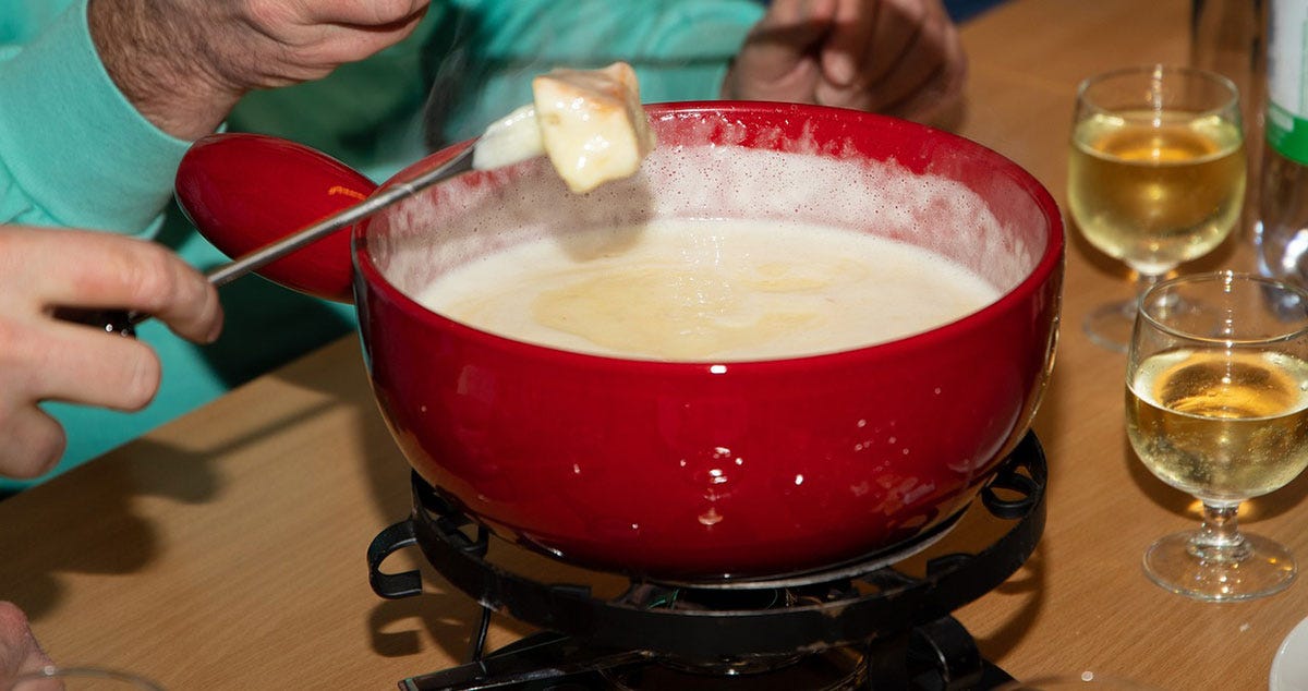 Cheese fondue involves melting cheese into a communal pot and dripping pieces of bread in it.
