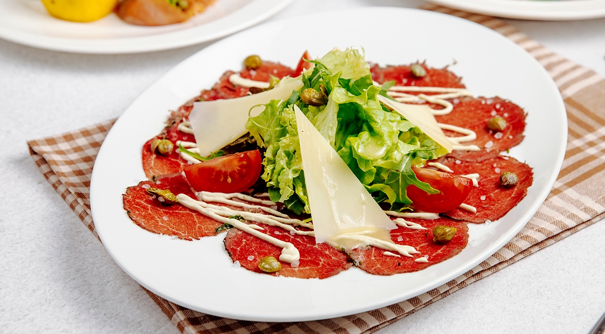 Carpaccio is thinly sliced or pounded beef, served raw. It was invented in 1963 by Giuseppe Cipriani from Harry's Bar in Venice, Italy.