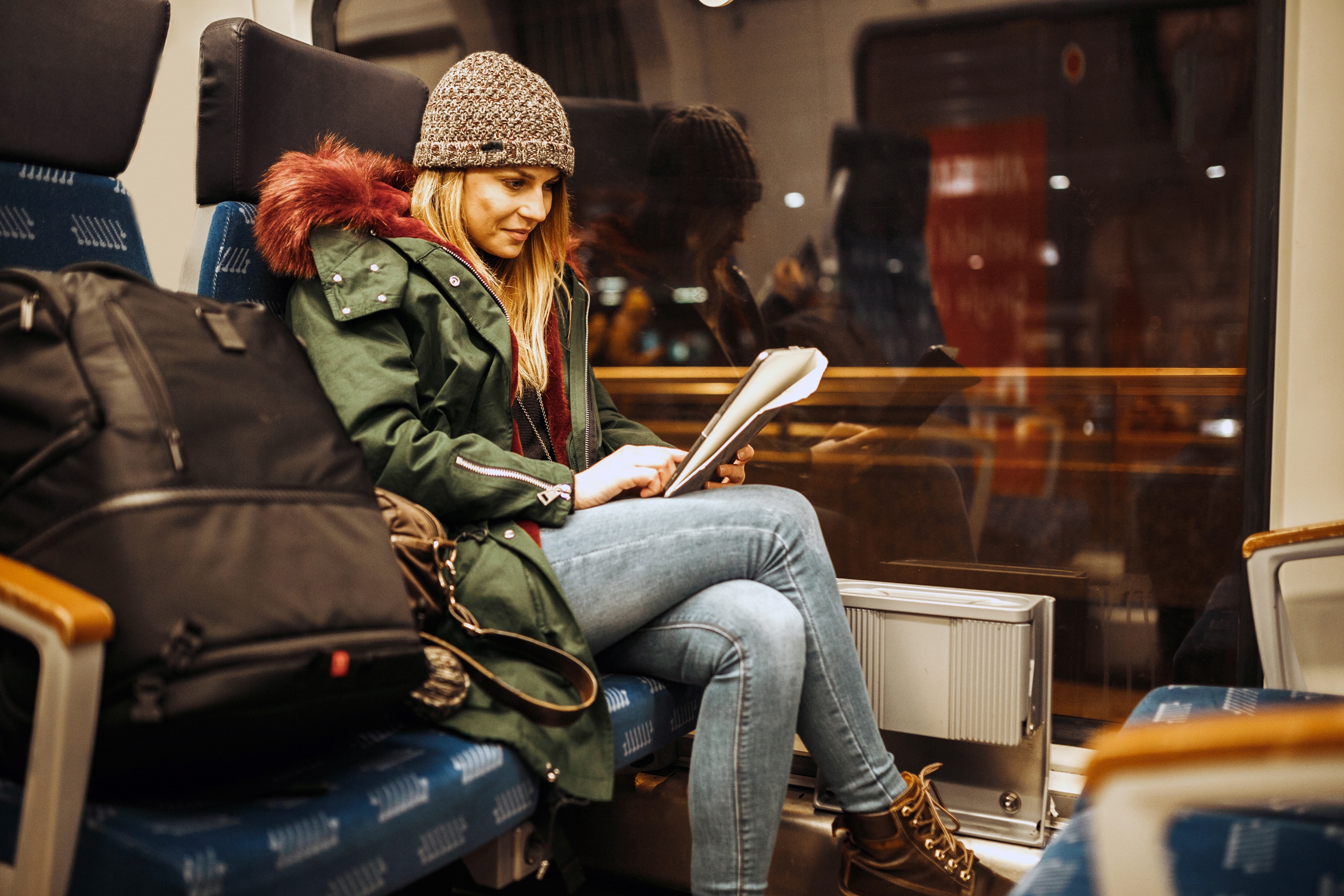 Woman on train reading Spanish forum to learn Spanish slang.
