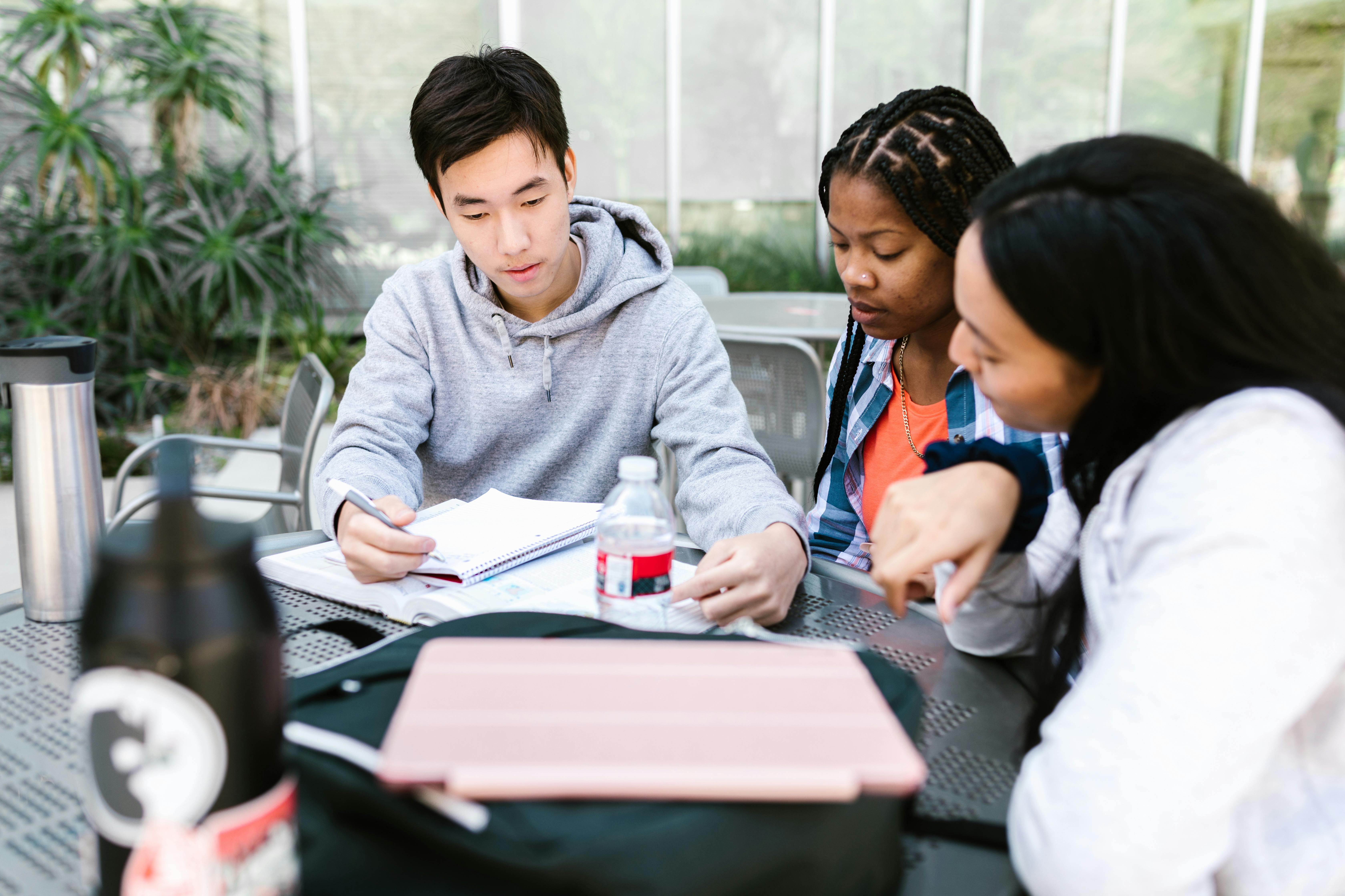 Group of students sitting around a table and practicing present perfect