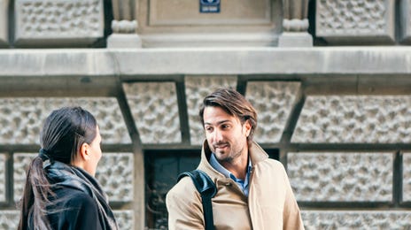 Man and woman conversing outside after attending Dutch classes near me in an urban setting.