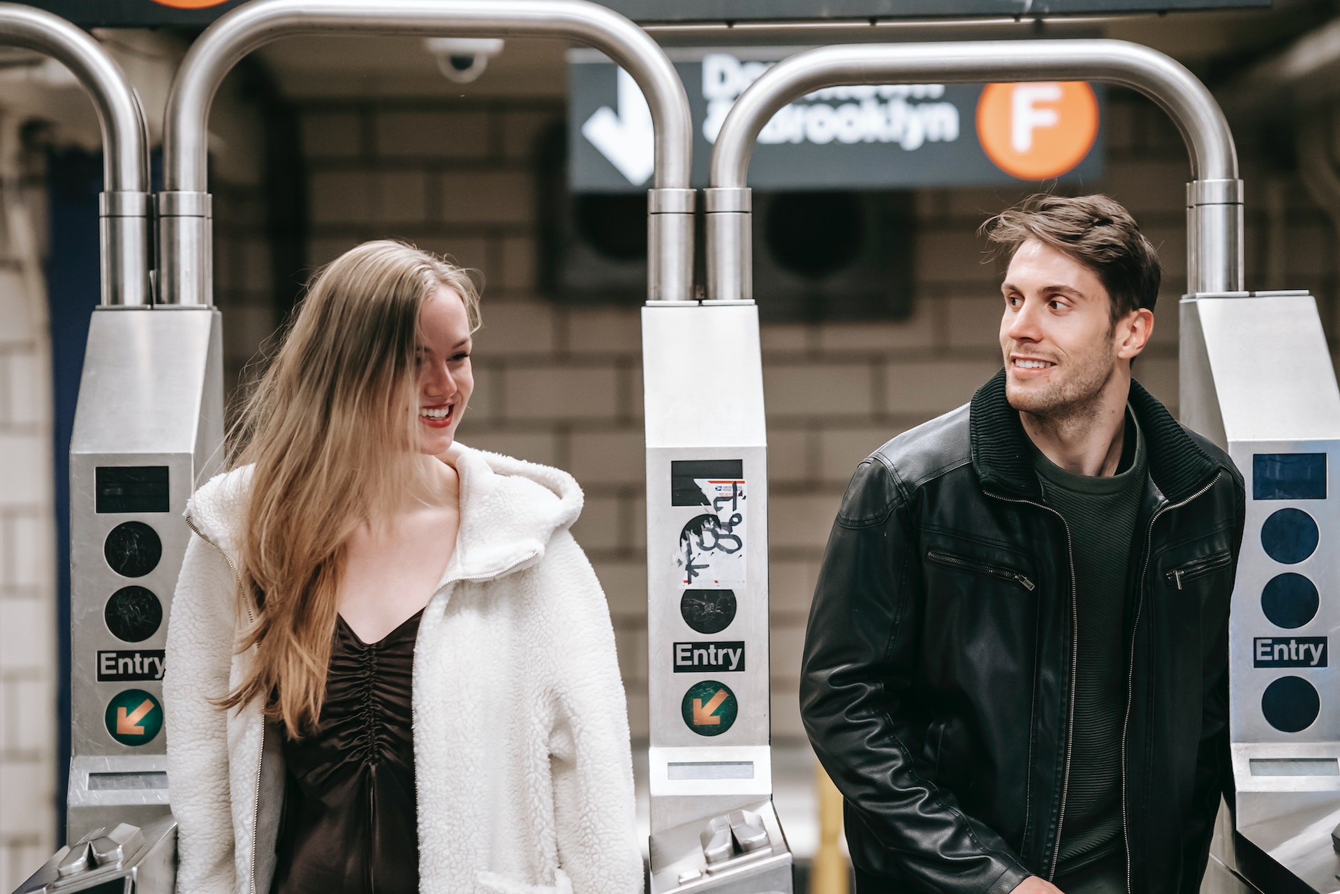 A cute couple are at the train station and showing us flirty body language and how to flirt in German