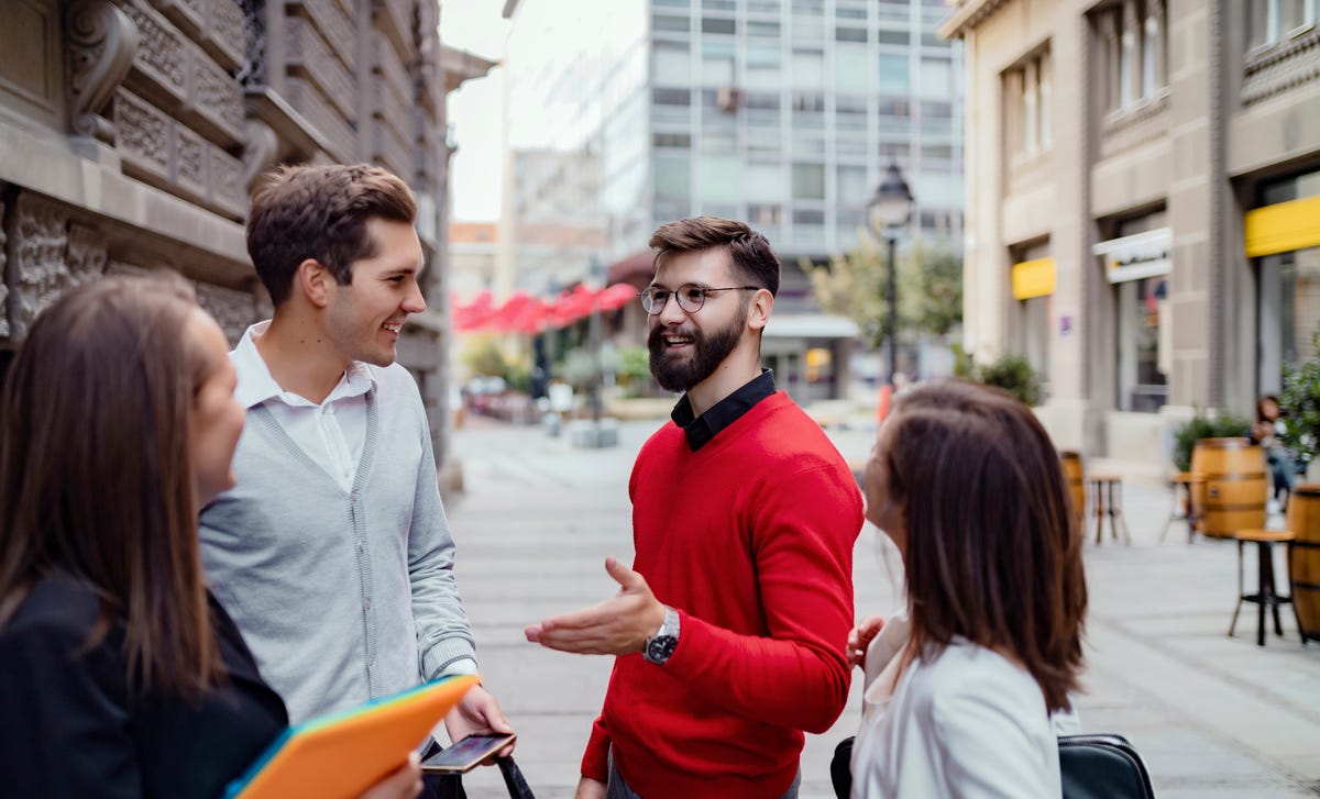 Group of young adults conversing in Croatian during a language course in an urban outdoor setting